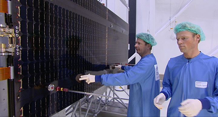 Galileo solar arrays being inspected in the Dutch Space cleanroom. The panels received from Ottobrunn in Germany are integrated together with the mechanisms, typically sourced from local Dutch companies assembled and tested by Dutch Space, into complete solar array wings. The completed wings are then suspended on specially weighted deployment rigs, to compensate for the presence of gravity the 29 kg wings are not designed to endure. Here alignment testing is performed, to check the wings will unfold in a straight line as planned.