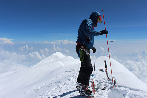 Blaine Horner of CompassData probing the snow pack at the highest point in North America along with setting up Global Position System equipment for precise summit elevation data. (Photo: Blaine Horner, CompassData)