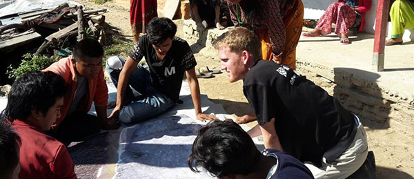 FIG Volunteer Community Surveyor working with locals to discuss parcel possession. (Photo: FIG Young Surveyors)