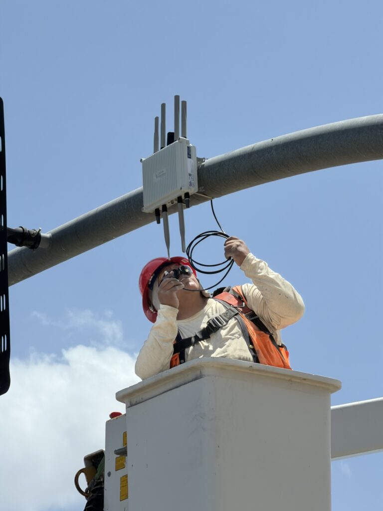 An MK6 Road-Side Unit being mounted to traffic infrastructure. (Credit: Cohda Wireless)